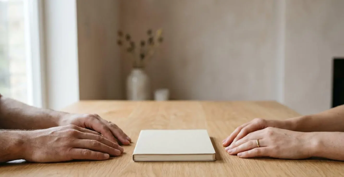Deux mains posées côte à côte sur une table avec un carnet vierge symbolisant l'écriture de règles communes