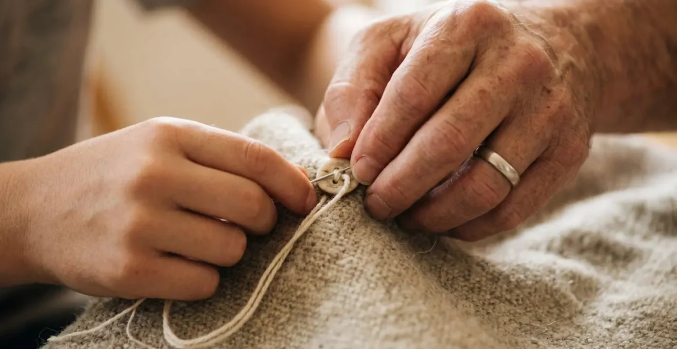 Gros plan sur des mains guidant l'apprentissage d'une tâche parentale avec douceur et patience